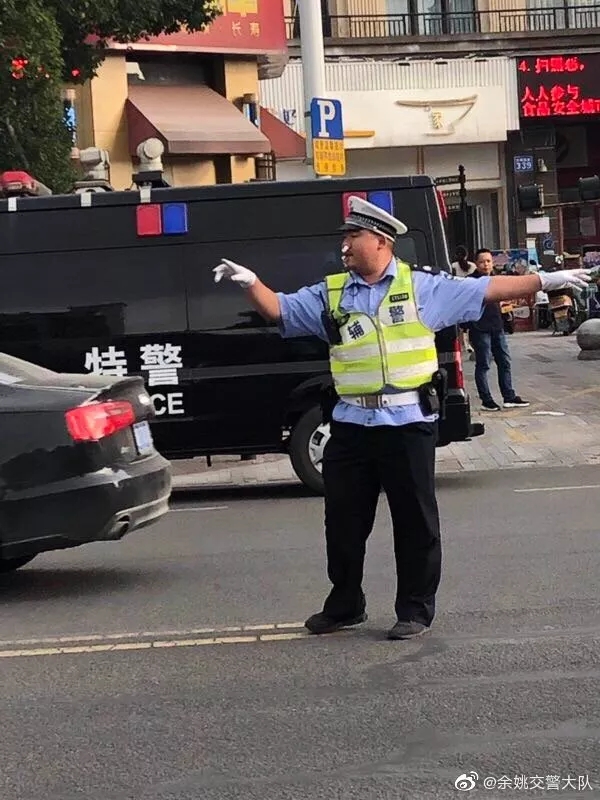 现场照片显示，一位交警在流鼻血的情况下，往鼻子了塞了张纸巾，就继续指挥交通。.jpg